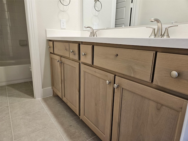 bathroom with tile patterned floors, vanity, and tiled shower / bath