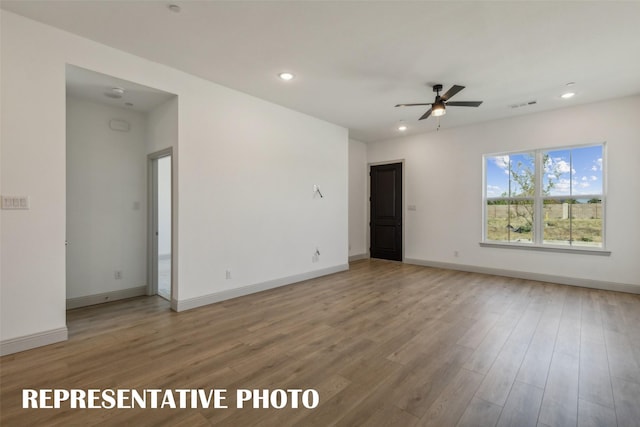 spare room featuring hardwood / wood-style floors and ceiling fan