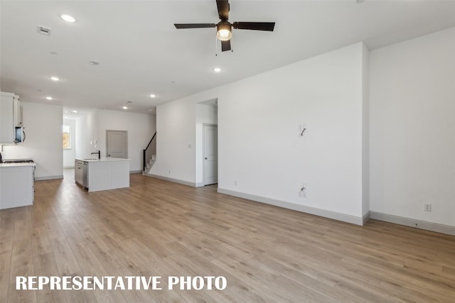 unfurnished living room with light hardwood / wood-style floors and ceiling fan