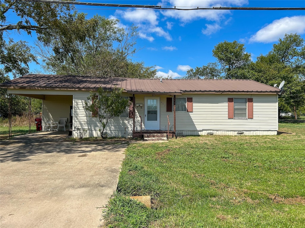 view of front of property featuring a front yard and a carport