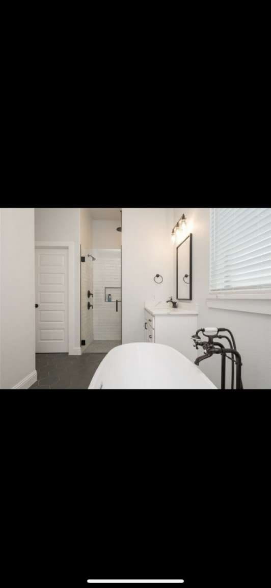 bathroom featuring walk in shower and vanity