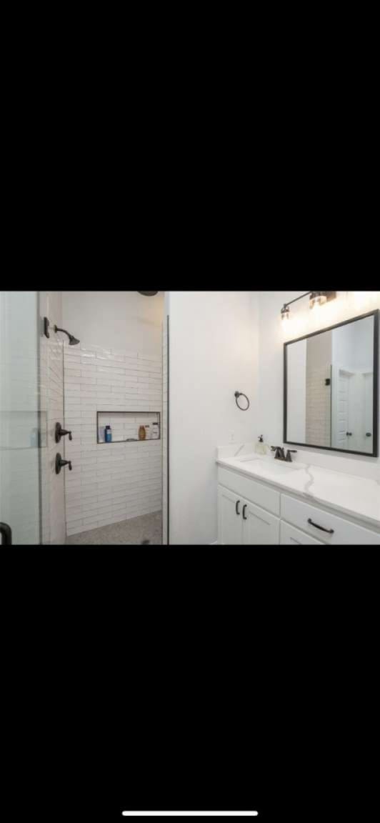 bathroom featuring vanity and a shower with door