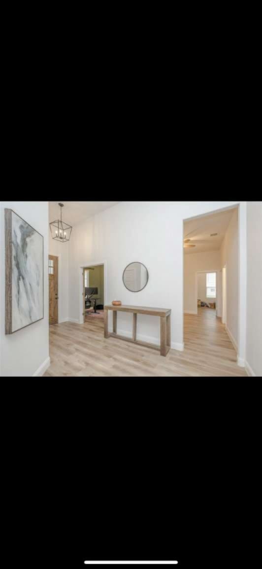 interior space with a notable chandelier and light hardwood / wood-style floors