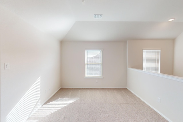 unfurnished room with vaulted ceiling and light colored carpet