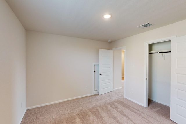 unfurnished bedroom featuring a closet and light carpet