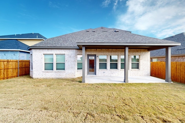 back of property with a patio area and a yard