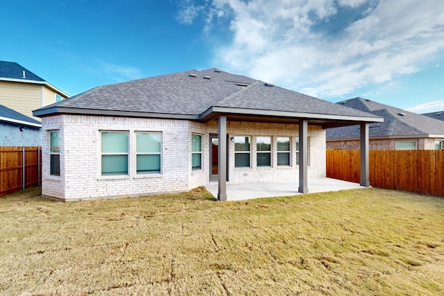 rear view of house featuring a yard and a patio