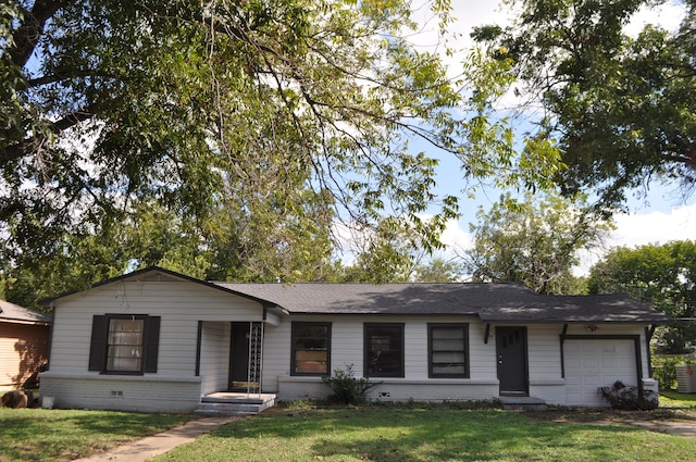 ranch-style house featuring a garage and a front lawn