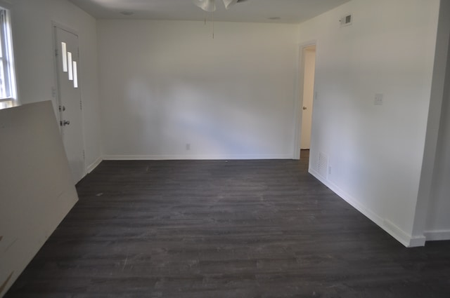 empty room with dark wood-type flooring and ceiling fan