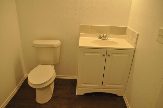 bathroom with vanity, toilet, and hardwood / wood-style flooring