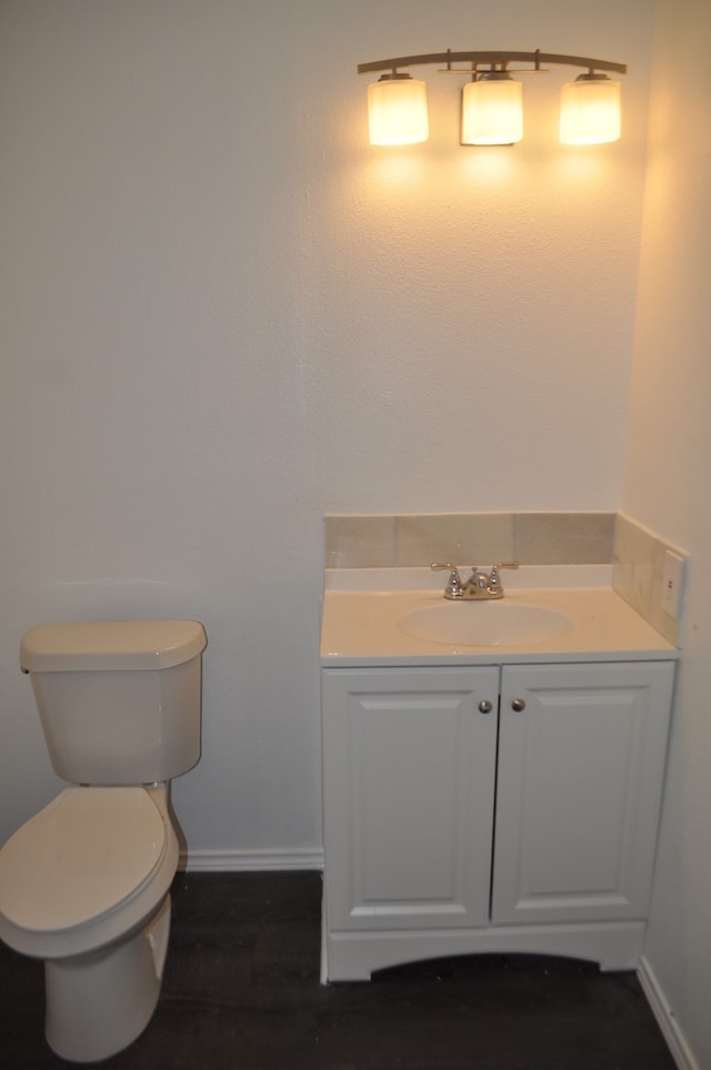 bathroom with wood-type flooring, toilet, and vanity