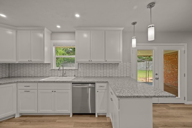 kitchen featuring light wood-type flooring, kitchen peninsula, white cabinetry, and stainless steel dishwasher