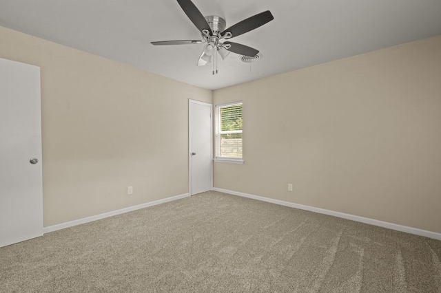 carpeted spare room with ceiling fan