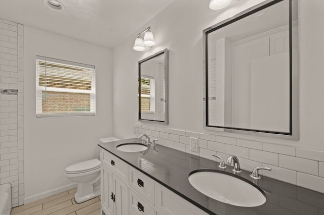 bathroom with vanity, toilet, hardwood / wood-style flooring, and tasteful backsplash