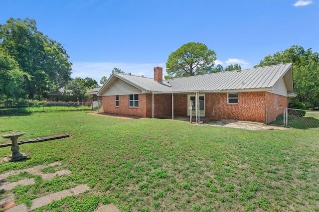 rear view of house with a yard and a patio