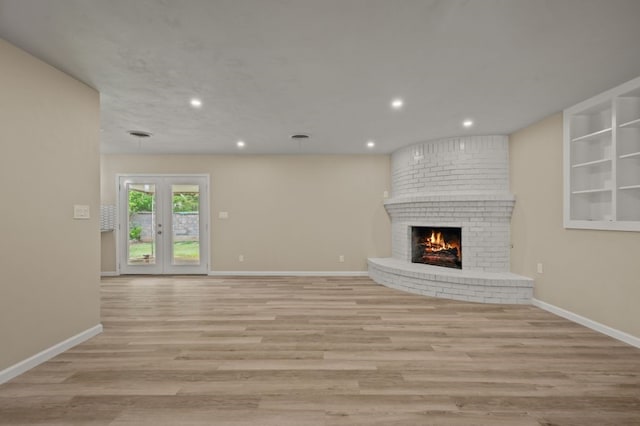 unfurnished living room with a fireplace and light wood-type flooring