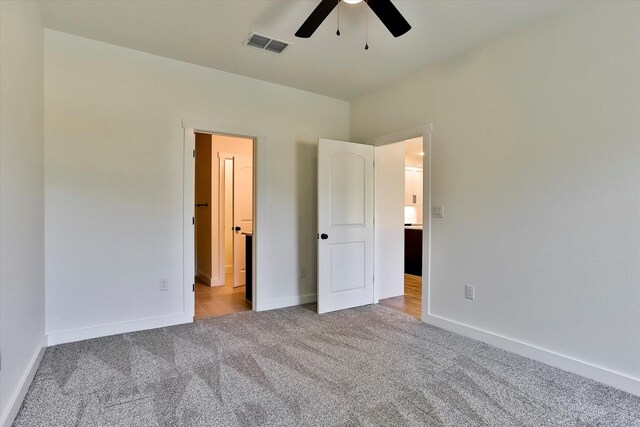 unfurnished bedroom with light colored carpet and ceiling fan