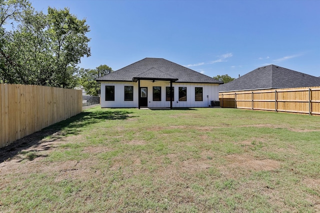 rear view of property with a yard and central air condition unit