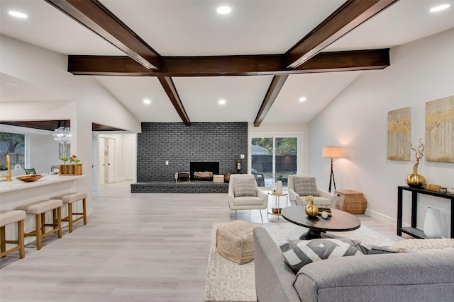 living room with a brick fireplace, vaulted ceiling with beams, and light wood-type flooring