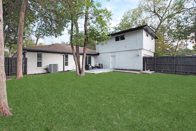 back of house with central AC unit, a yard, and a patio