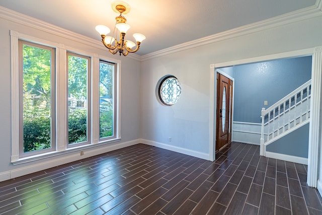 spare room with ornamental molding, dark hardwood / wood-style floors, and a chandelier