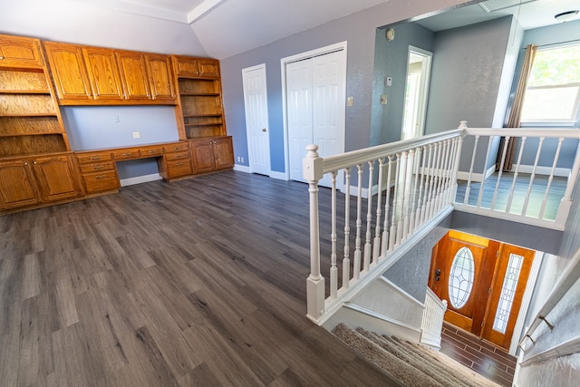 interior space featuring built in desk, vaulted ceiling, and hardwood / wood-style flooring