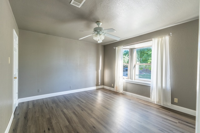 empty room featuring ceiling fan, a textured ceiling, and dark hardwood / wood-style floors