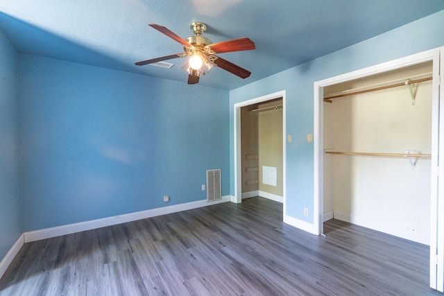 unfurnished bedroom with ceiling fan, a textured ceiling, a closet, and dark hardwood / wood-style floors