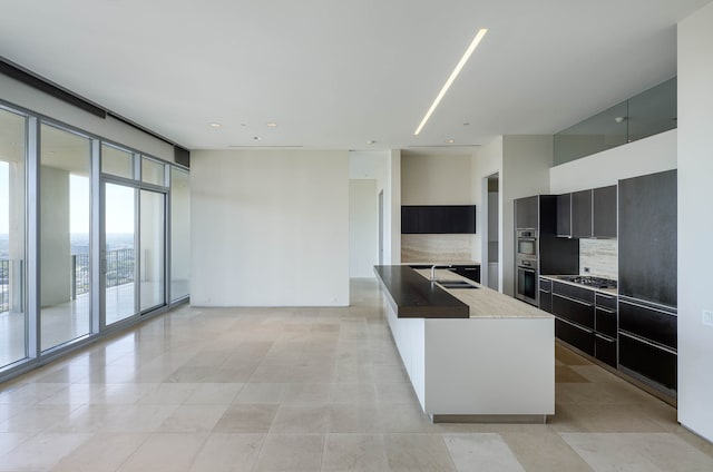 kitchen featuring a kitchen island, appliances with stainless steel finishes, decorative backsplash, and light tile patterned floors