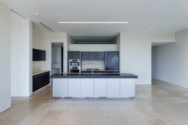 kitchen featuring tasteful backsplash, a center island, light tile patterned flooring, and stainless steel double oven