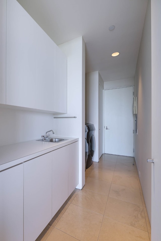 corridor with light tile patterned flooring, washing machine and dryer, and sink