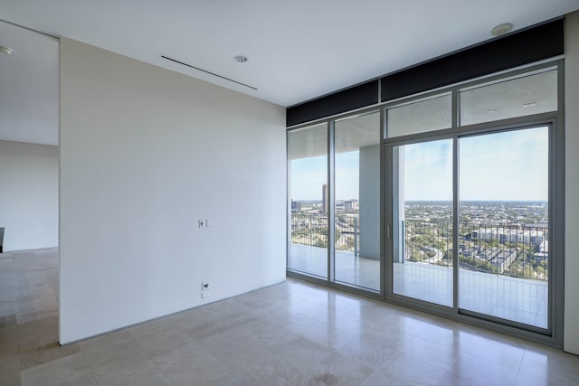 spare room with light tile patterned flooring and floor to ceiling windows