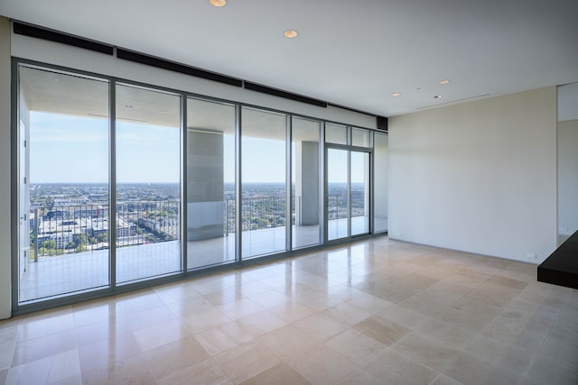 empty room featuring expansive windows and light tile patterned floors