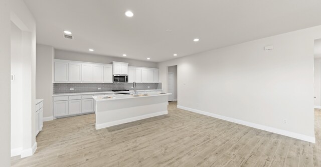 kitchen featuring sink, white cabinets, light wood-type flooring, and appliances with stainless steel finishes