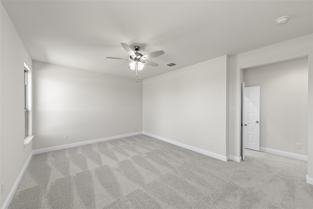 spare room with ceiling fan and light carpet