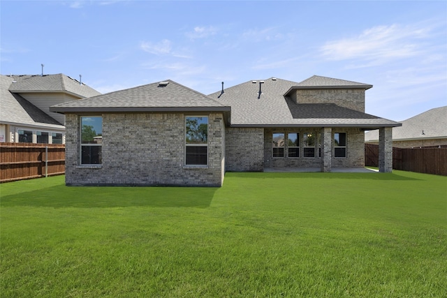 rear view of property featuring a lawn