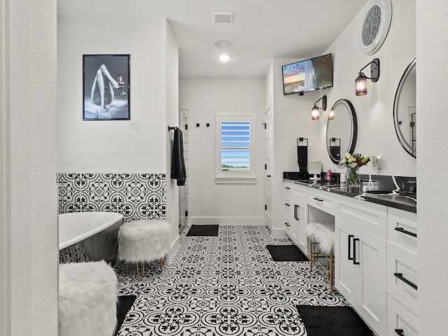 bathroom with vanity, a tub to relax in, and tile patterned floors