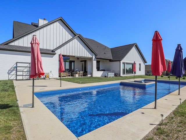 view of swimming pool with a lawn and a patio area