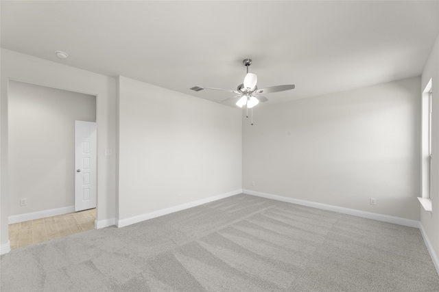 carpeted spare room featuring ceiling fan