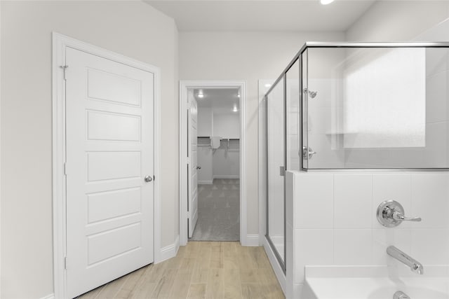 bathroom with hardwood / wood-style flooring and a shower with door