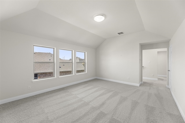 interior space featuring vaulted ceiling and light colored carpet