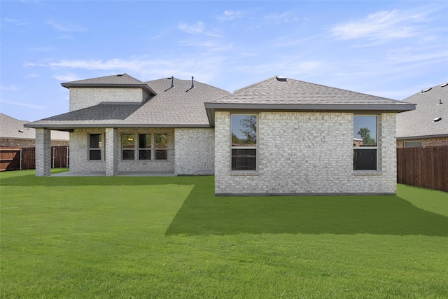 back of house featuring a lawn and a patio area