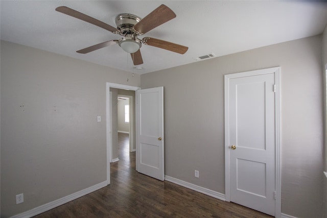 unfurnished bedroom with ceiling fan and dark hardwood / wood-style flooring