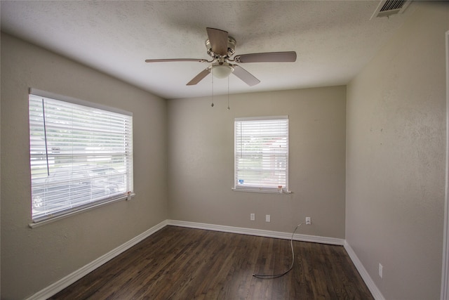 empty room featuring dark hardwood / wood-style floors, ceiling fan, and a textured ceiling