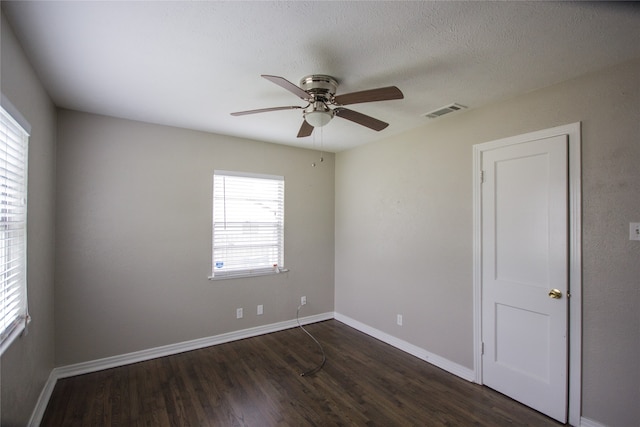 spare room with ceiling fan, dark hardwood / wood-style flooring, and a textured ceiling