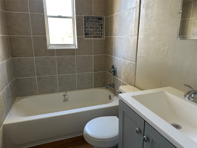 full bathroom featuring tile patterned floors, vanity, toilet, and tiled shower / bath combo