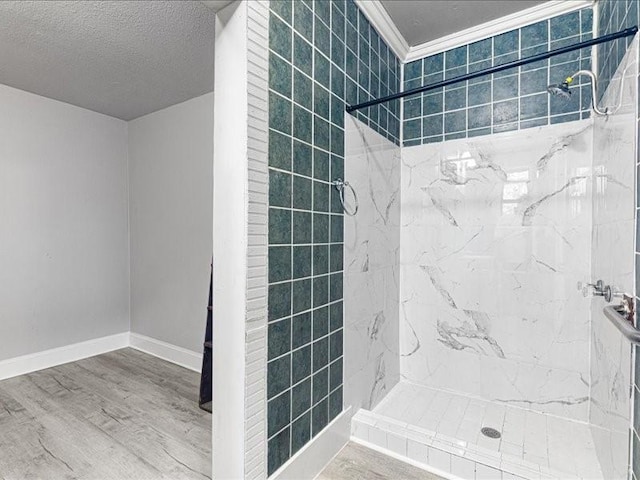 bathroom featuring crown molding, hardwood / wood-style flooring, a textured ceiling, and tiled shower