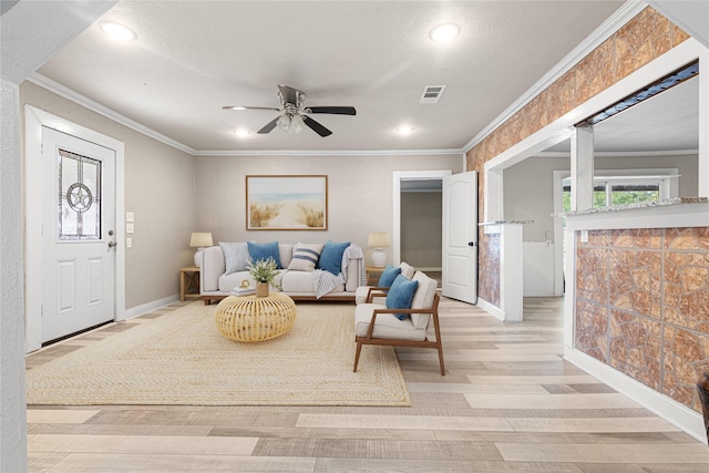 living room with crown molding, ceiling fan, and light wood-type flooring