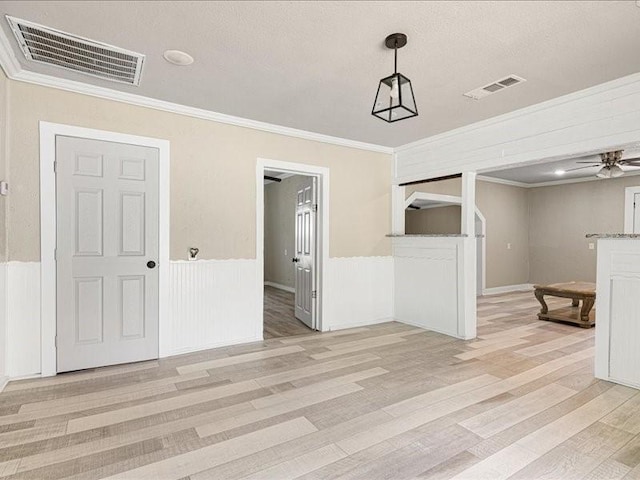 interior space featuring ceiling fan, ornamental molding, and light hardwood / wood-style floors