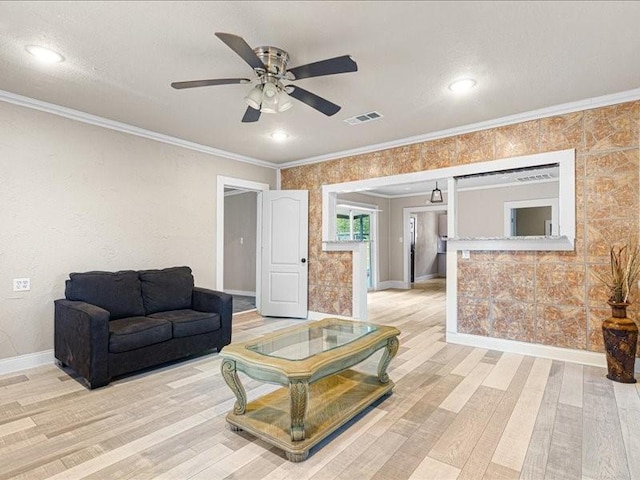 living room with ornamental molding, ceiling fan, and light wood-type flooring